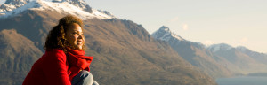 Woman sitting on a mountain spiritually happy