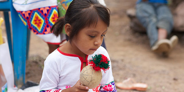 Huichol girl with a ceremonial rattle