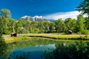 A beautiful scenic pond with mountain range in the background.