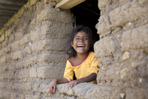 Huichol Girl Laughing in hut window